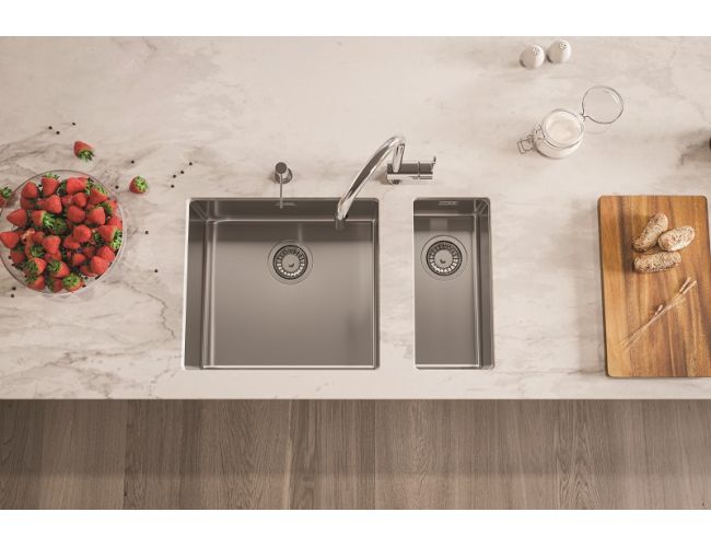 Minimalistično inox kuhinjsko korito z dvema koritoma in elegantno pipo na svetlem kuhinjskem pultu