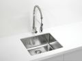 Inox kuhinjsko pomivalno korito z visoko vzmetno armaturo s tušem, vgrajeno v bel kuhinjski pult.