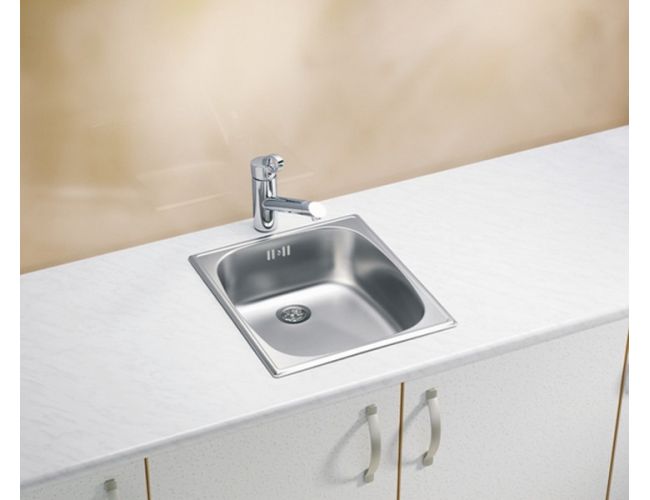 Majhno inox kuhinjsko pomivalno korito s kromirano enoročno armaturo, vgrajeno v svetel kuhinjski pult nad belimi omaricami.