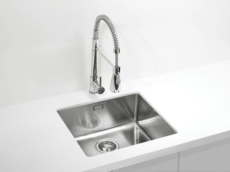 Inox kuhinjsko pomivalno korito z visoko vzmetno armaturo s tušem, vgrajeno v bel kuhinjski pult.